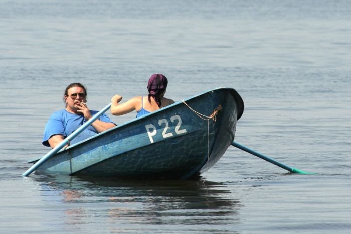 Man of the Year Finalist, man smokes while wife rows boat, woman rowing boat